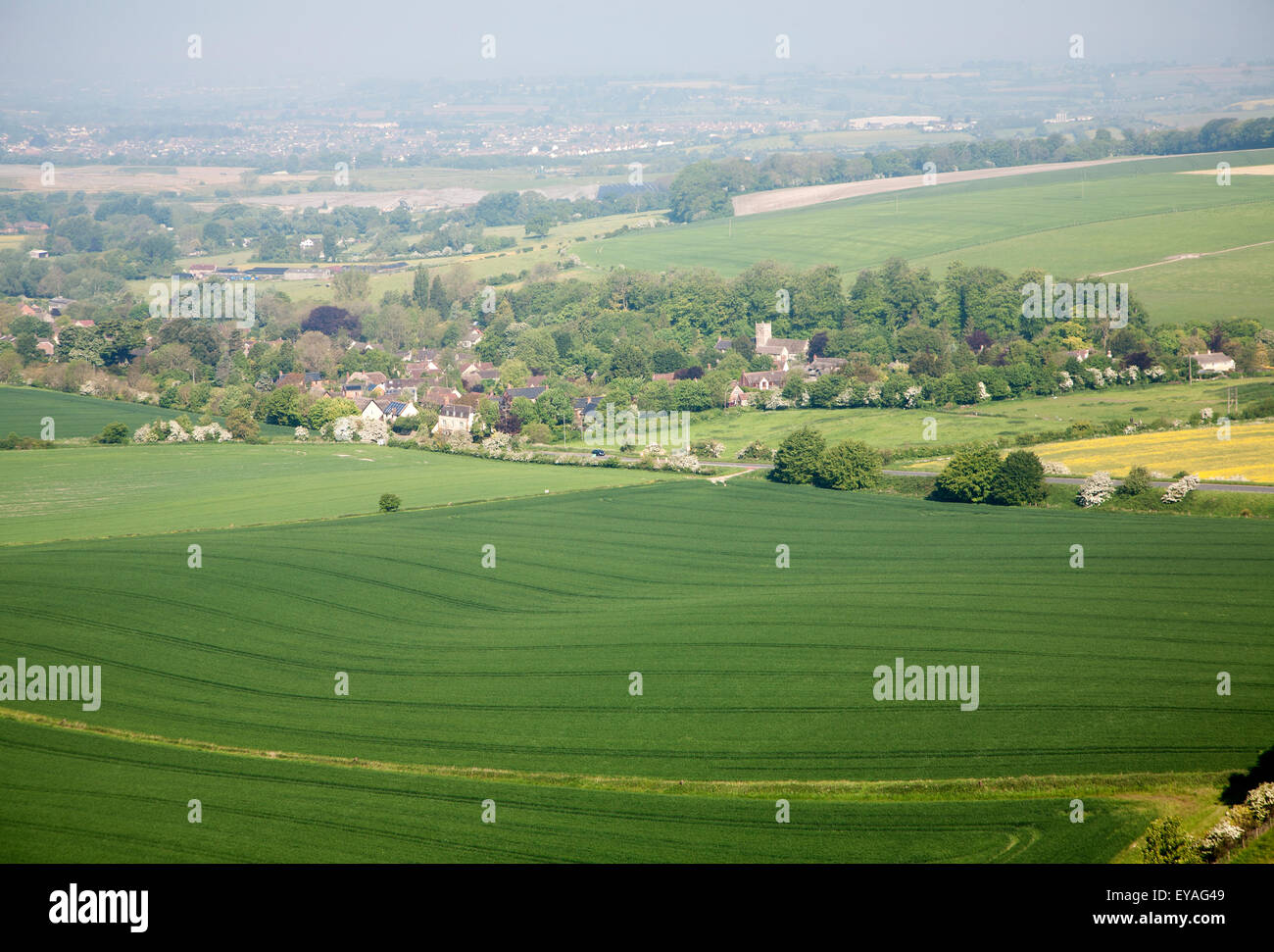 Vista estiva campi arabili a Cherhill villaggio dal Cherhill giù scarpata, Wiltshire, Inghilterra, Regno Unito Foto Stock
