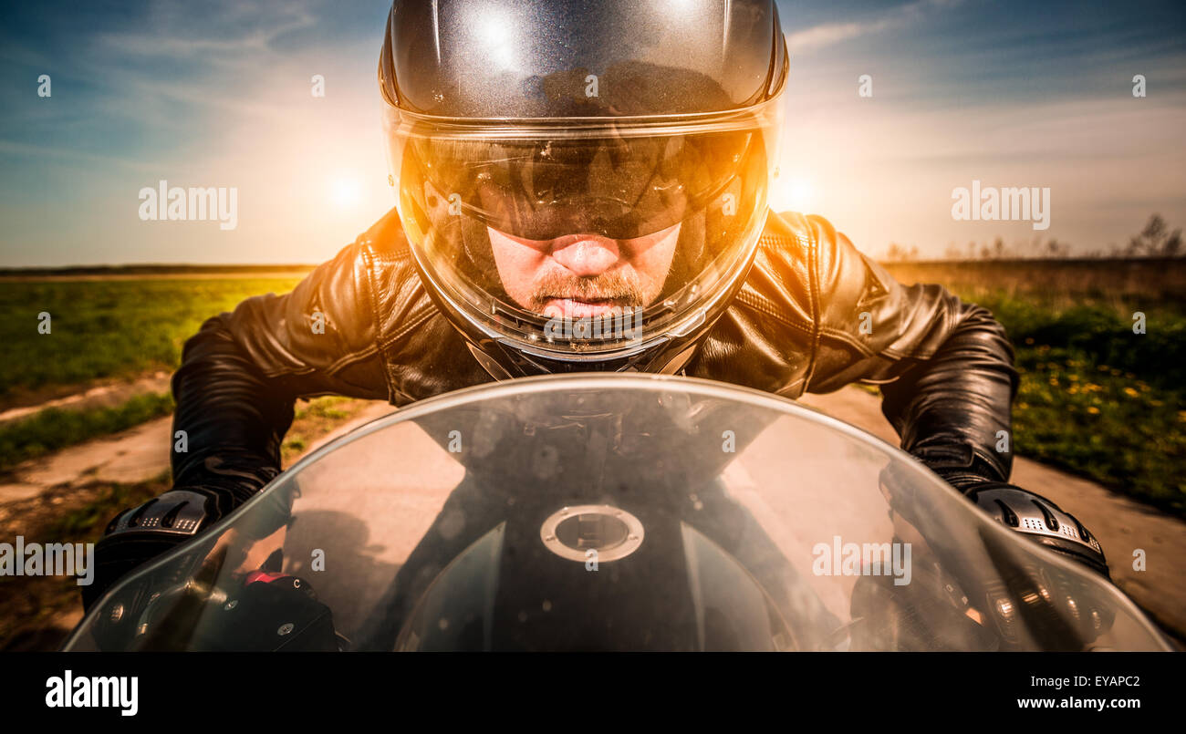 Biker in casco e giacca di pelle racing su strada Foto Stock Biker in casco e giacca di pelle racing su strada Foto Stock
