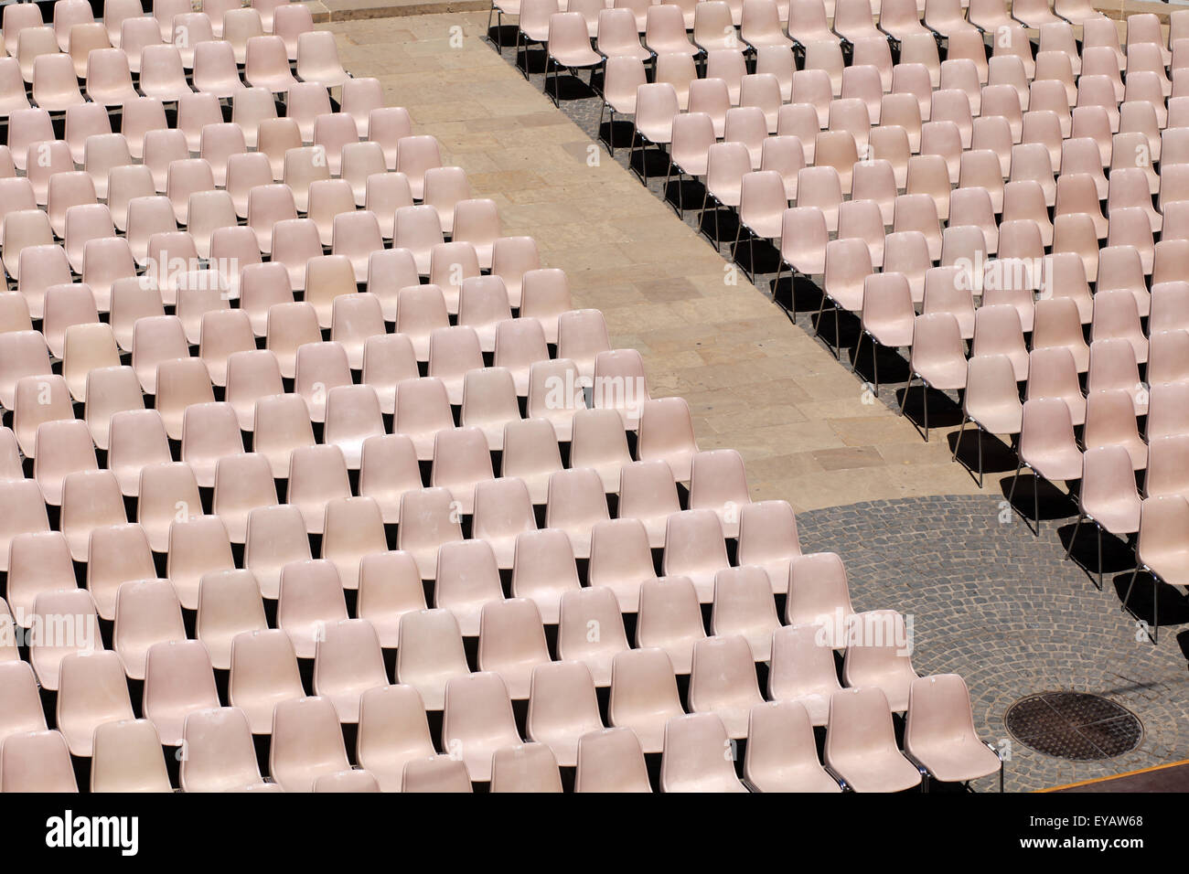 Molti luce rosa sedie allineate per il concerto, parola o altro evento Foto Stock