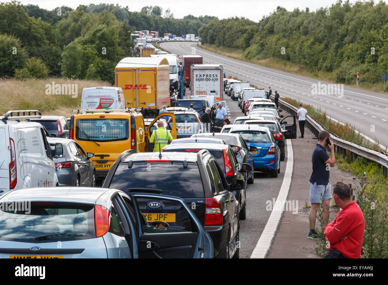 Ingorgo di traffico stazionario su una autostrada nel Regno Unito con la gente che camminava per strada Foto Stock