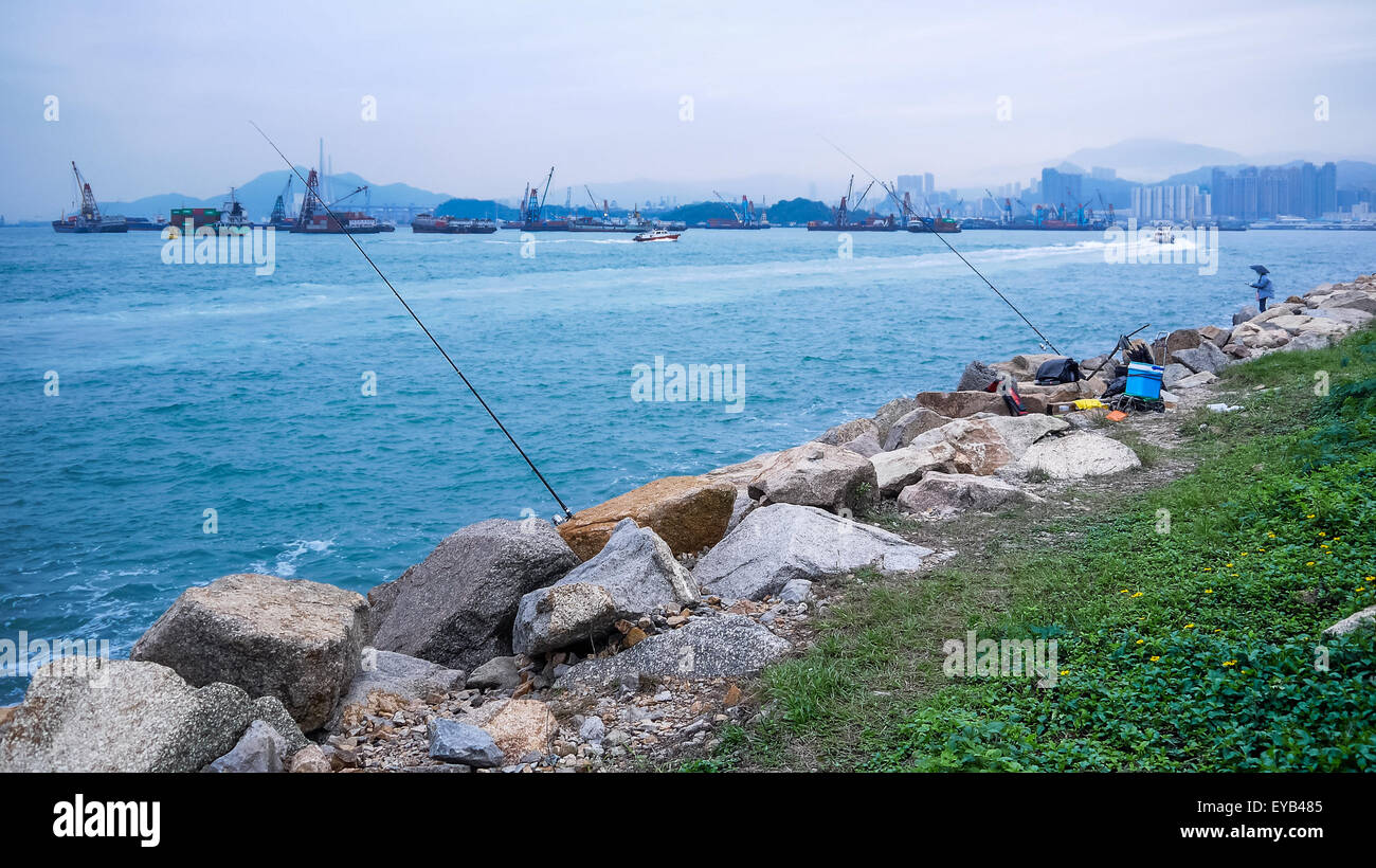 Canne da pesca a fianco del porto di Victoria a ovest della penisola di Kowloon, Hong Kong Foto Stock