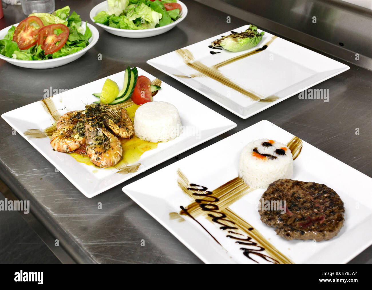 Il cibo italiano: i gamberetti, verdure e burger nel piatto quadrato Foto Stock