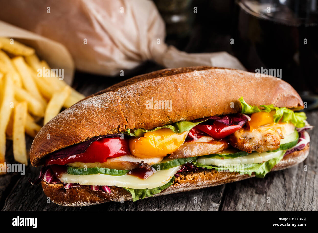 Sandwich di Pollo, patatine fritte e bicchiere di soda Foto Stock