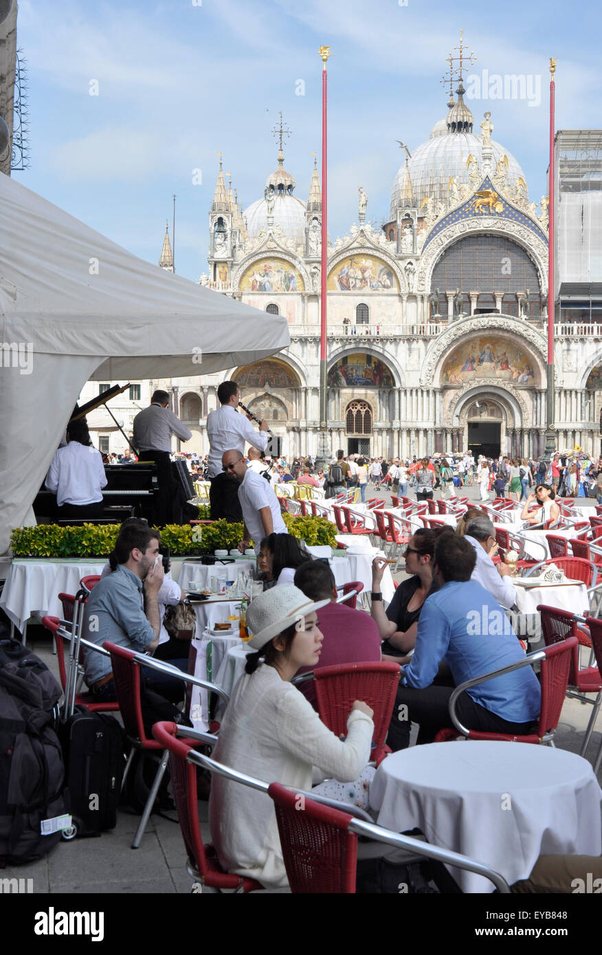 Italia - Venezia - Piazza San Marco - le donne da solo al tavolo del bar - in attesa - sfondo occupato cafè - orchestra - San Marco facciata Foto Stock