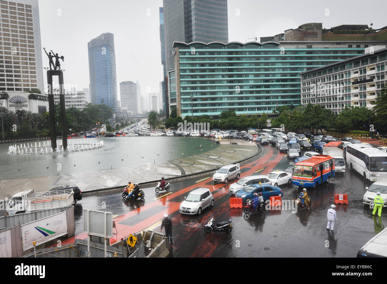 Traffico stradale a Bundaran HI (Hotel Indonesia Roundabout) in una giornata piovosa nel centro di Jakarta, Jakarta, Indonesia. Foto Stock