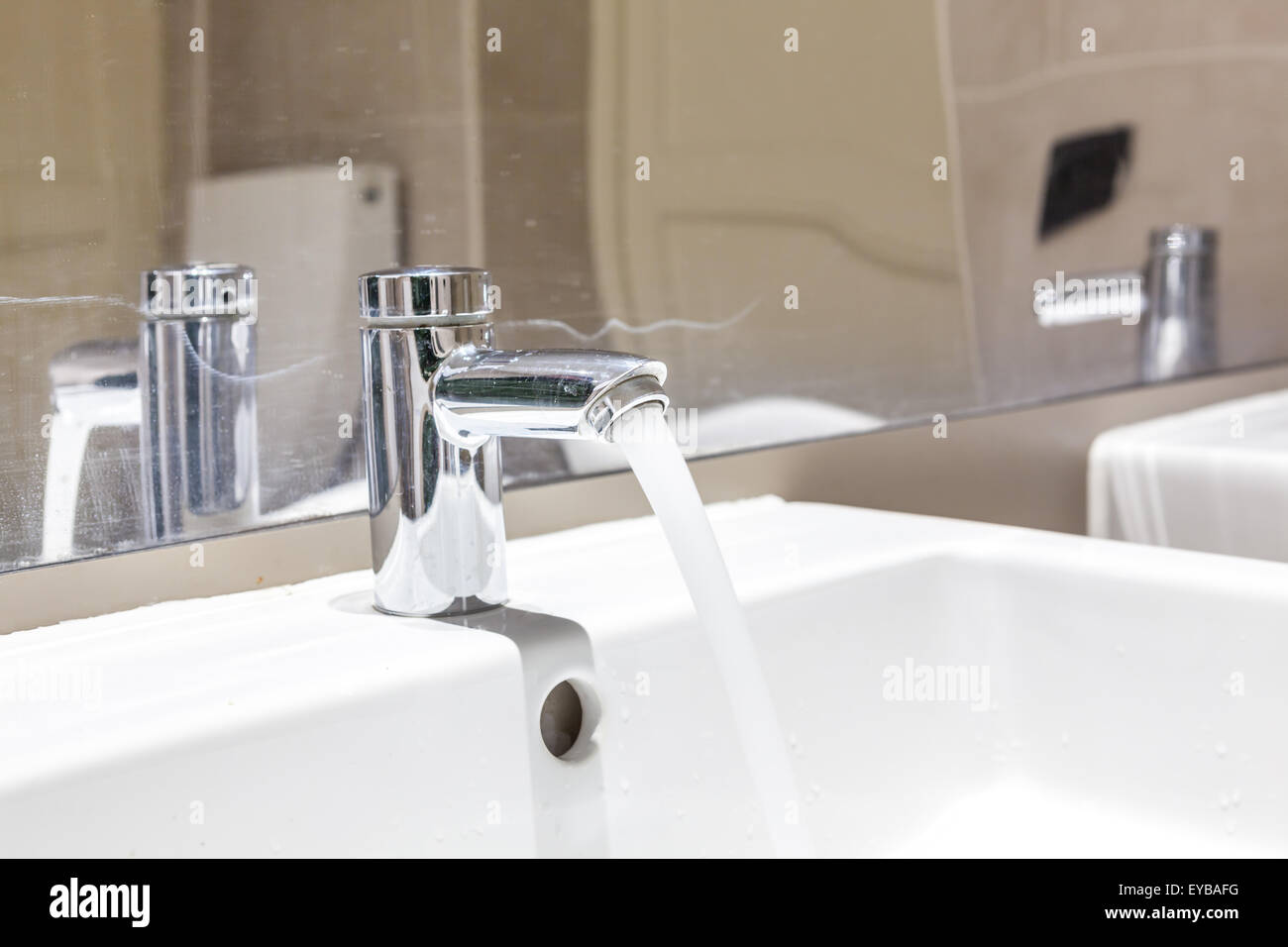 Nel bagno vi è un rubinetto di acqua che è aperta Foto Stock