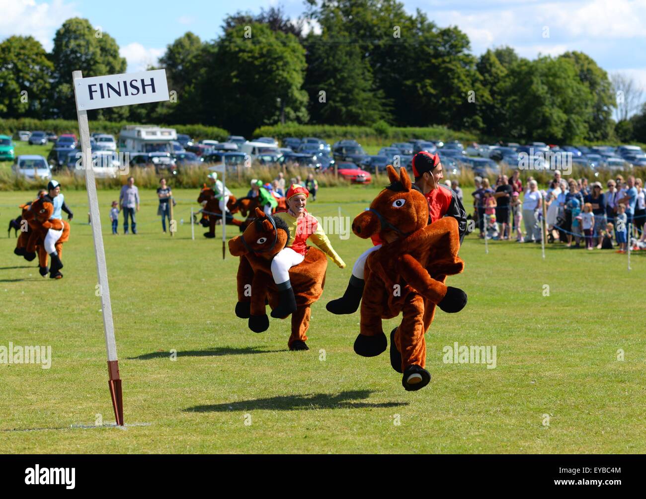 Jockeys corse nella corsa di cavalli di abbigliamento fantasia Damerham Derby al Damerham Fair and Horticultural Show, Hampshire, Regno Unito Foto Stock