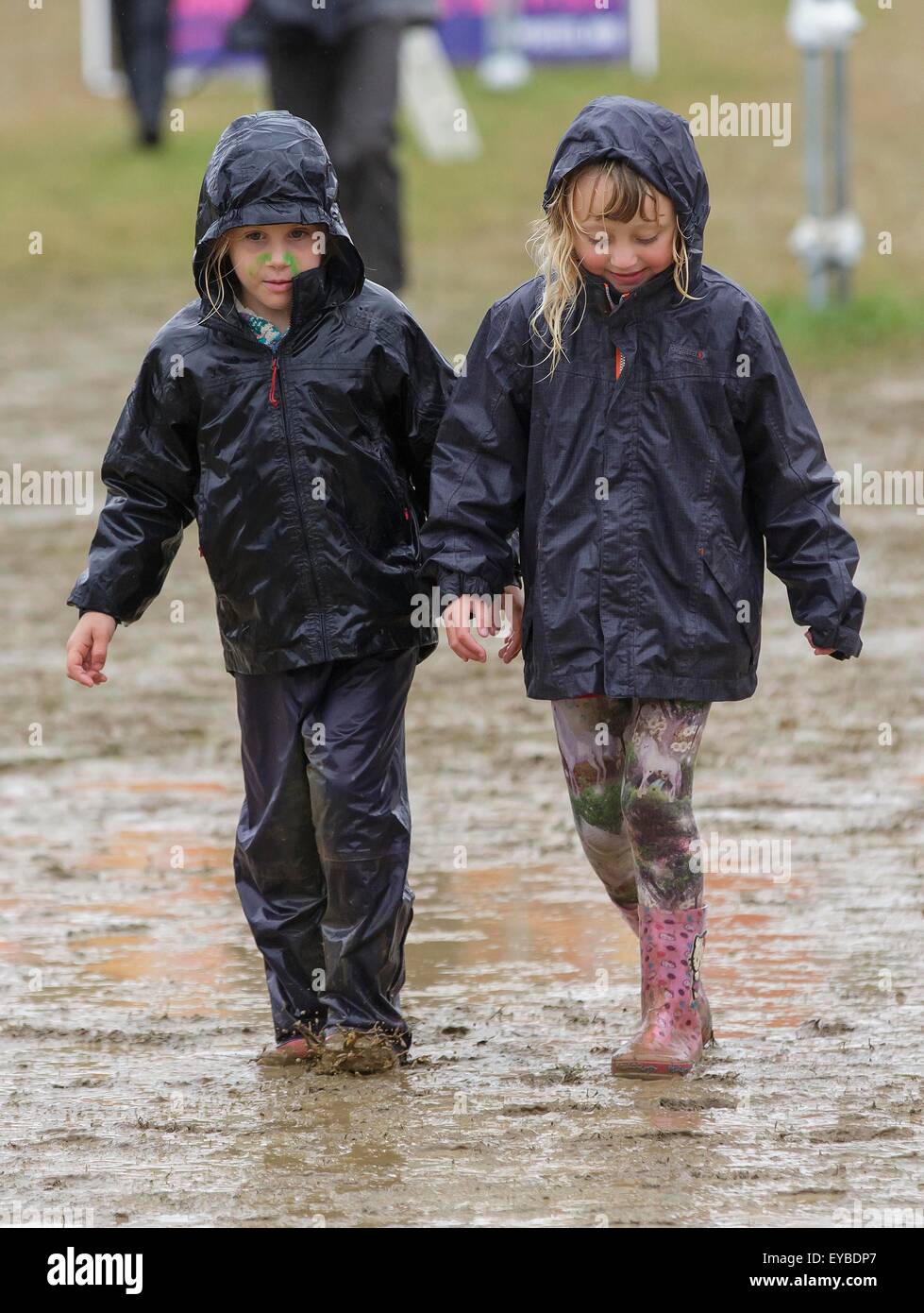 Malmesbury, Wiltshire, Regno Unito. 26 Luglio, 2015. Due bambini a piedi attraverso il fango e la pioggia a Womad Festival tenutosi a Charlton Park, nel Gloucestershire. Il 26 luglio 2015. Credito: Adam Gasson/Alamy Live News Foto Stock