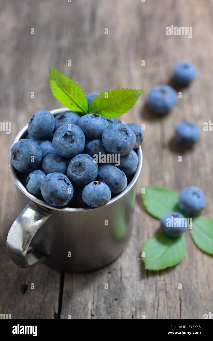 Bicchiere di metallo e mirtillo su legno vecchio Foto Stock