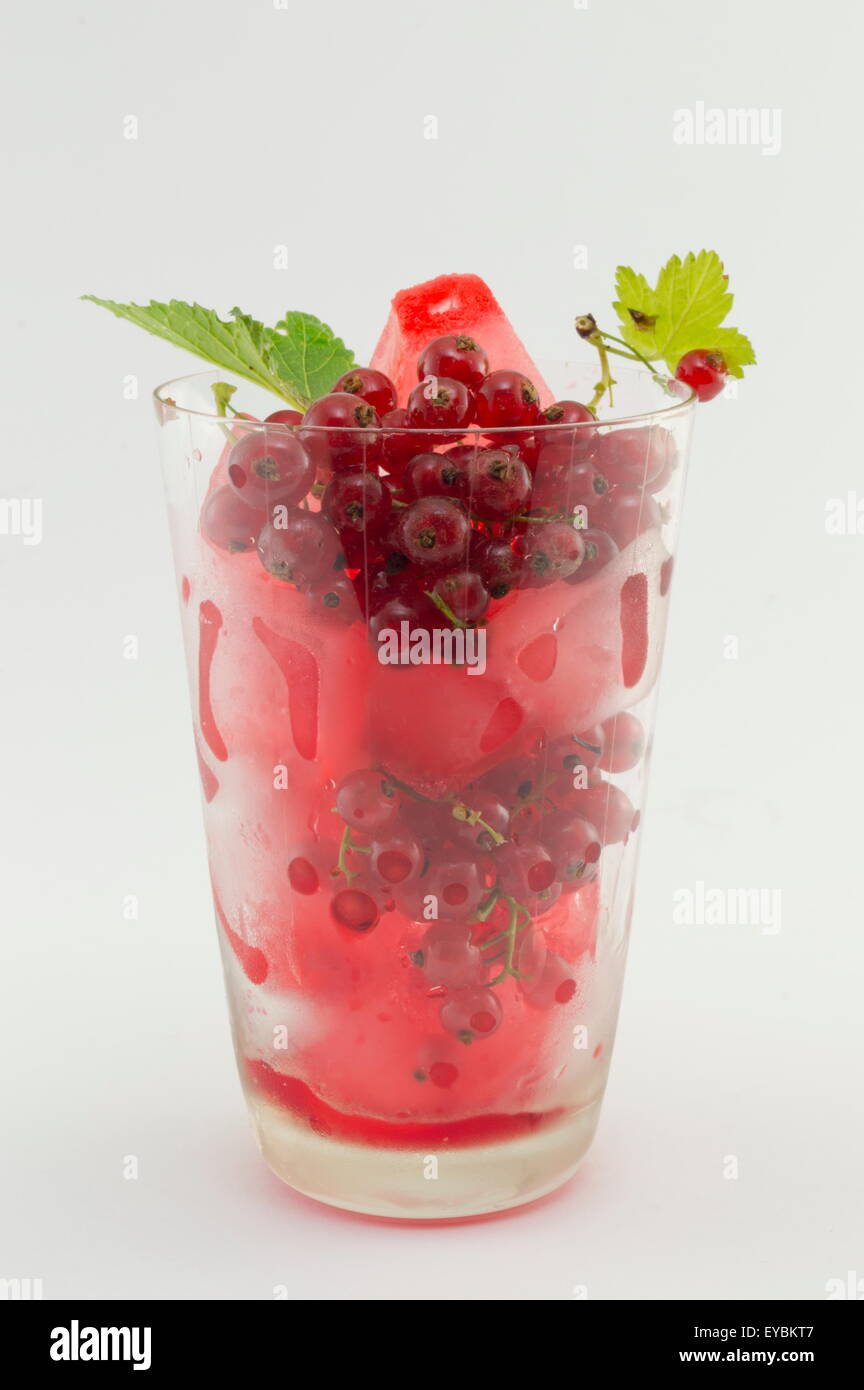 Ribes tè ghiacciato in un bicchiere con fresca frutta ribes isolato Foto Stock