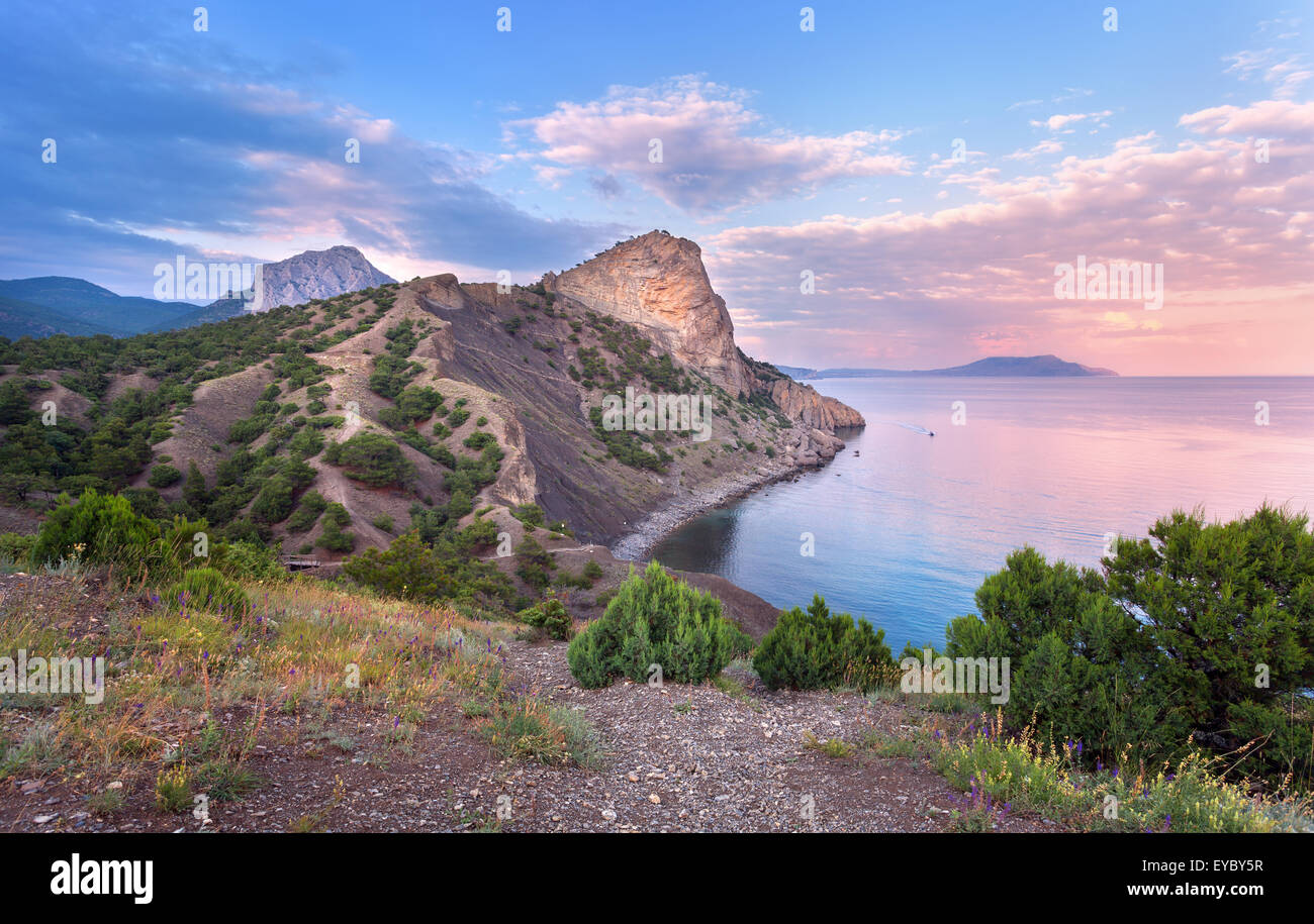 Bella estate tramonto al mare con montagne, alberi e cielo blu in Crimea Foto Stock