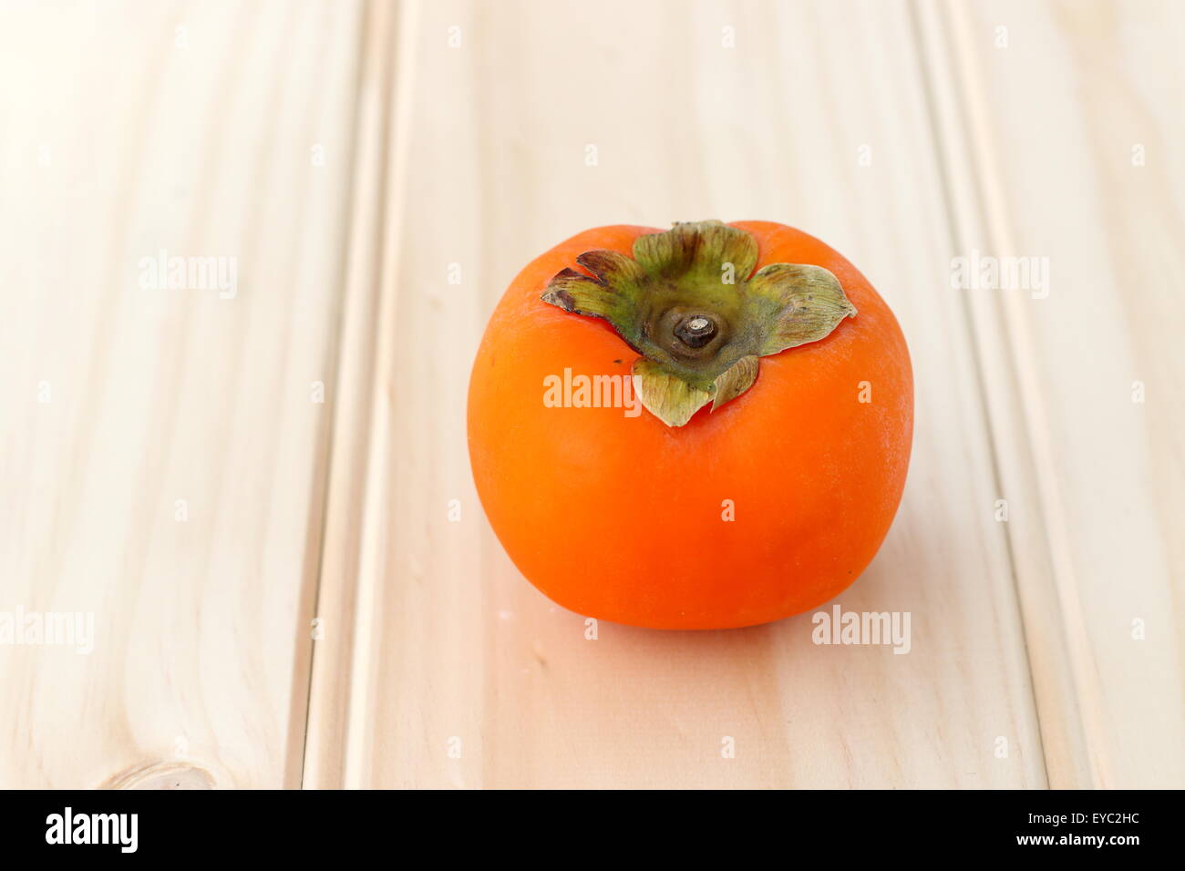 Uno fresco colore arancio kaki su una tavola di legno Foto Stock