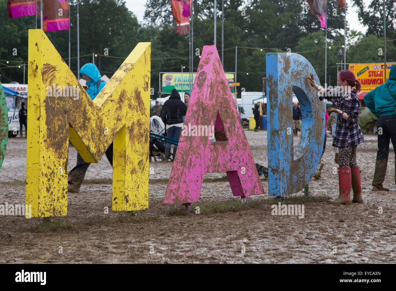 Wiltshire, Regno Unito. 26 Luglio, 2015. La domenica è il giorno finale del festival Womad (il mondo della musica e della danza). L'atmosfera di festa continua nonostante la pioggia persistente e successiva mudbath. I frequentatori del festival hanno ora ribattezzato il caso "WOMUD'. Una sfilata di carnevale inizia la sera intrattenimento seguita da famosi artisti di musica Ghostpoet e Laura Mvula. Credito: Wayne Farrell/Alamy Live News Foto Stock