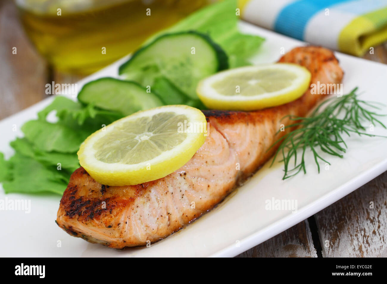 Salmone alla griglia con limone e insalata verde Foto Stock