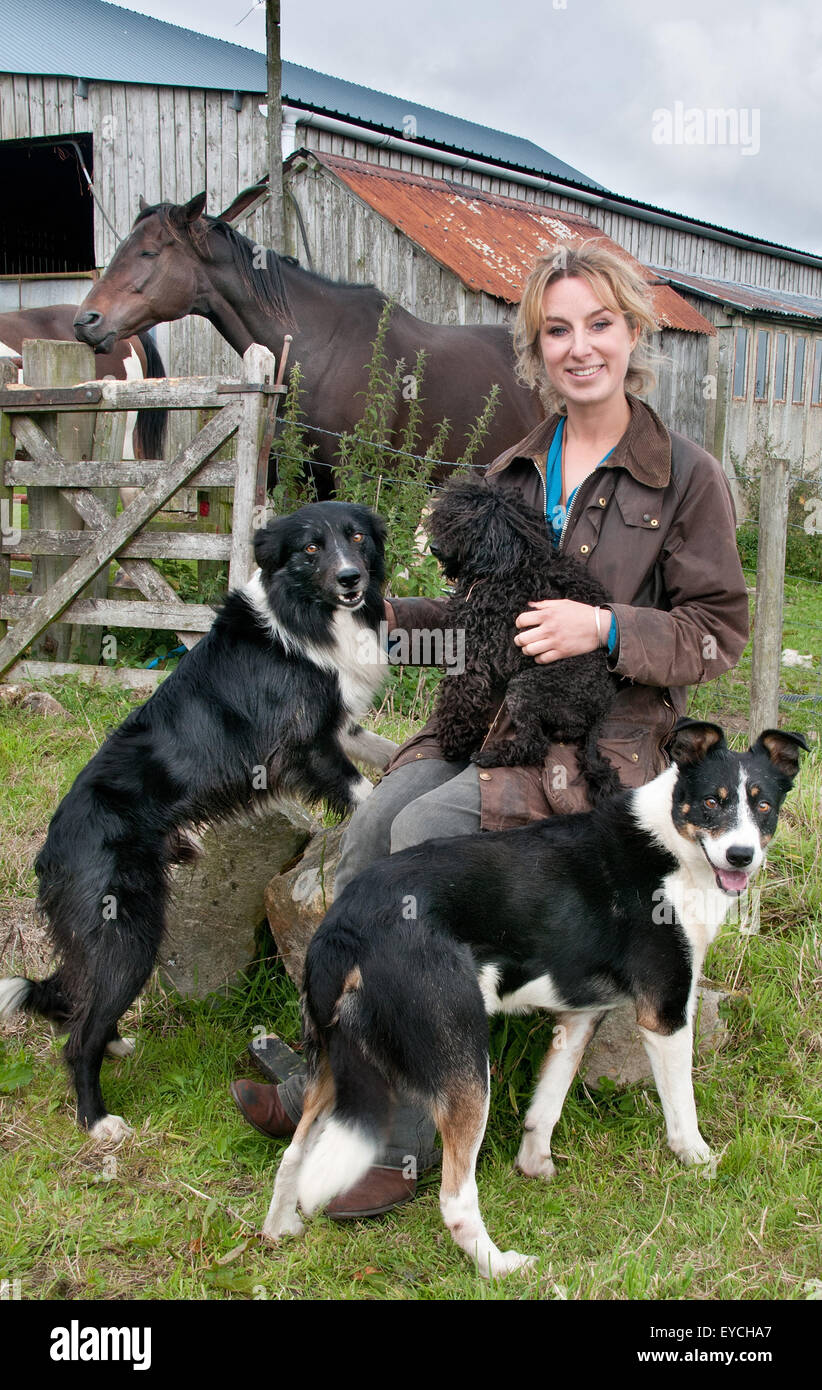 Una ragazza e i suoi cani, la pastorella Emma Gray alla Fattoria di Fallowlees con i suoi cani e cavalli, ora si è riallocata all'isola di Bute Foto Stock