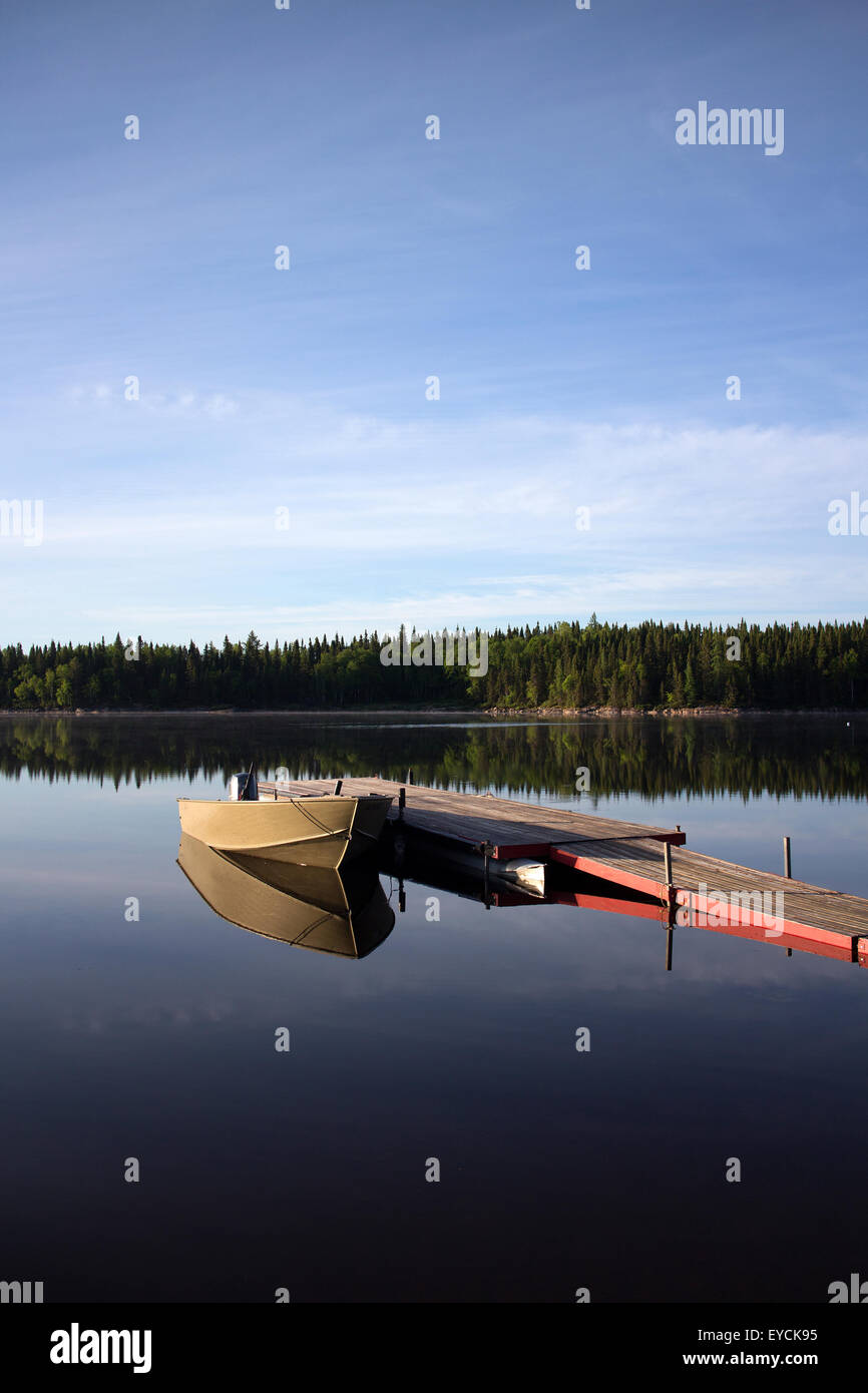 Il molo di legno con piccola barca su una tranquilla mattina Foto Stock