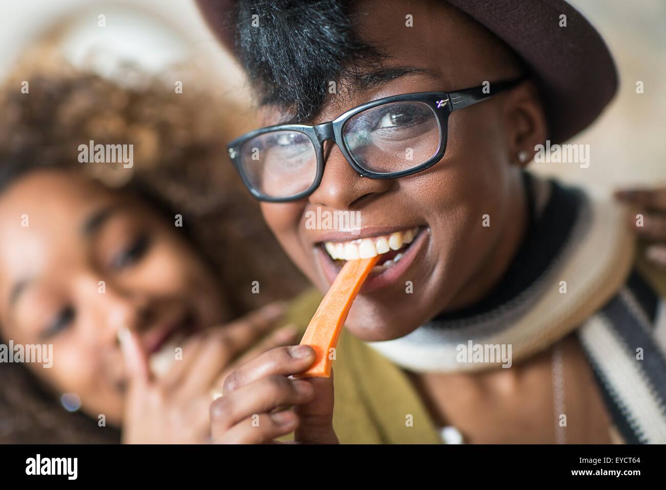 Giovani donne mangiare piatti per le feste in cucina Foto Stock