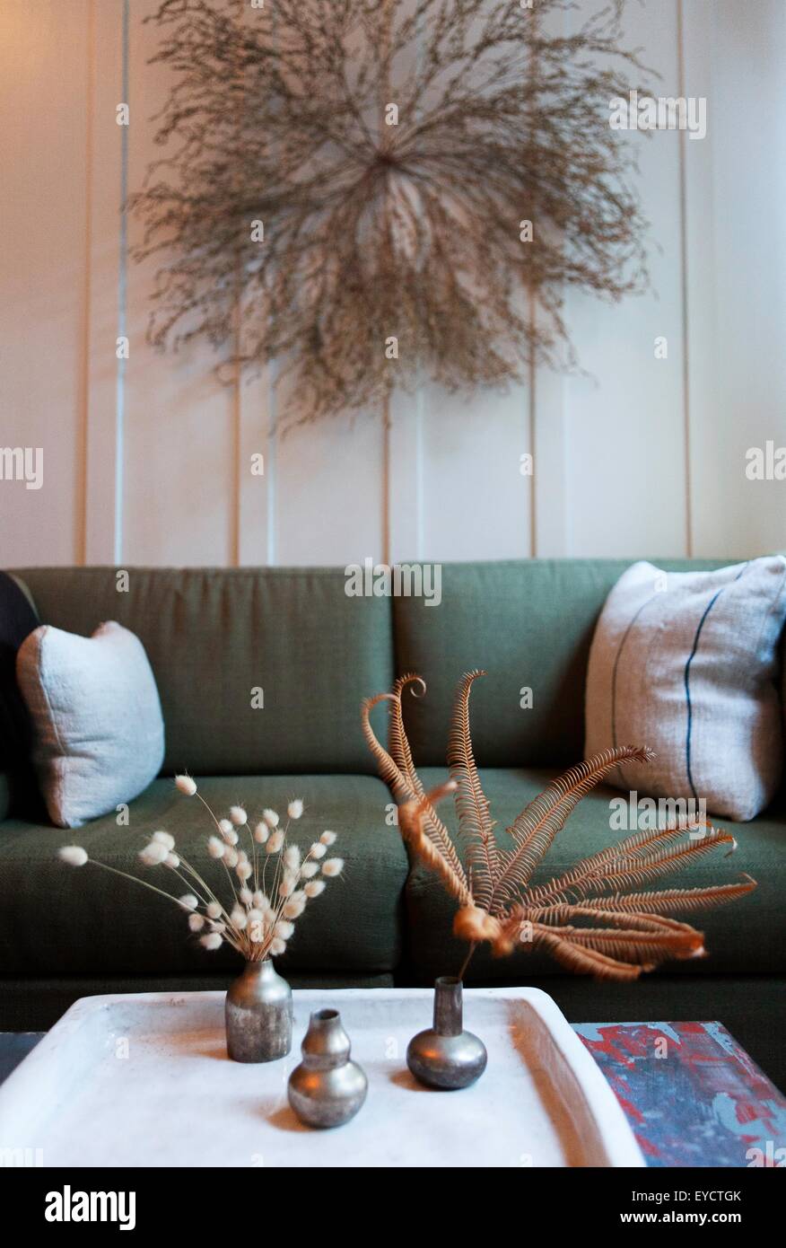 La stanza di seduta con secchi fiori sulla parete e tavolo da caffè Foto Stock