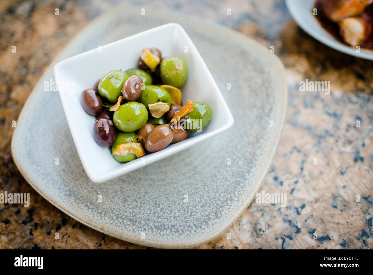 Ciotola di olive nere e verdi sulla tavola di ristorante Foto Stock