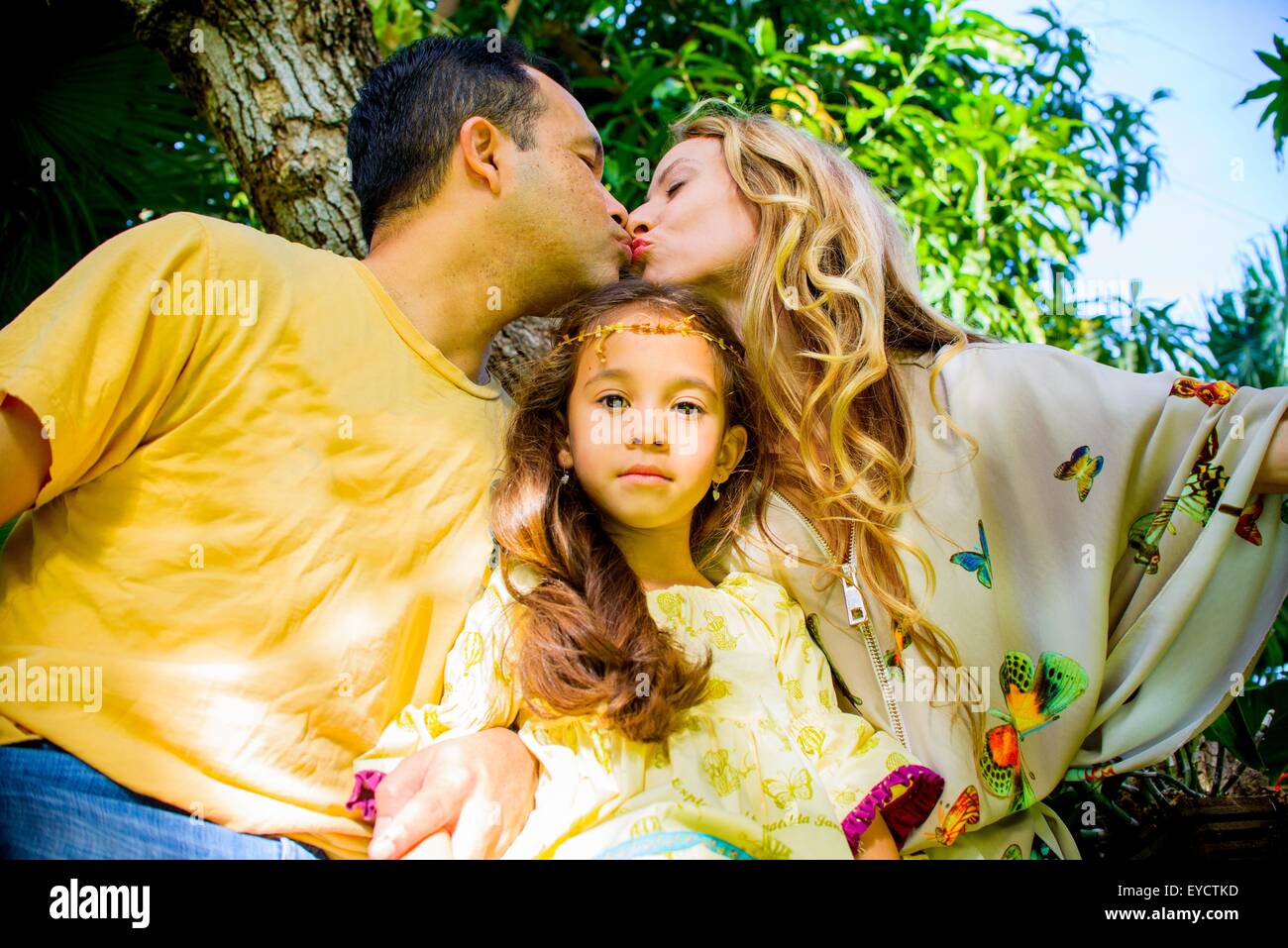 Ritratto di una ragazza tra affettuoso genitori maturi in giardino Foto Stock