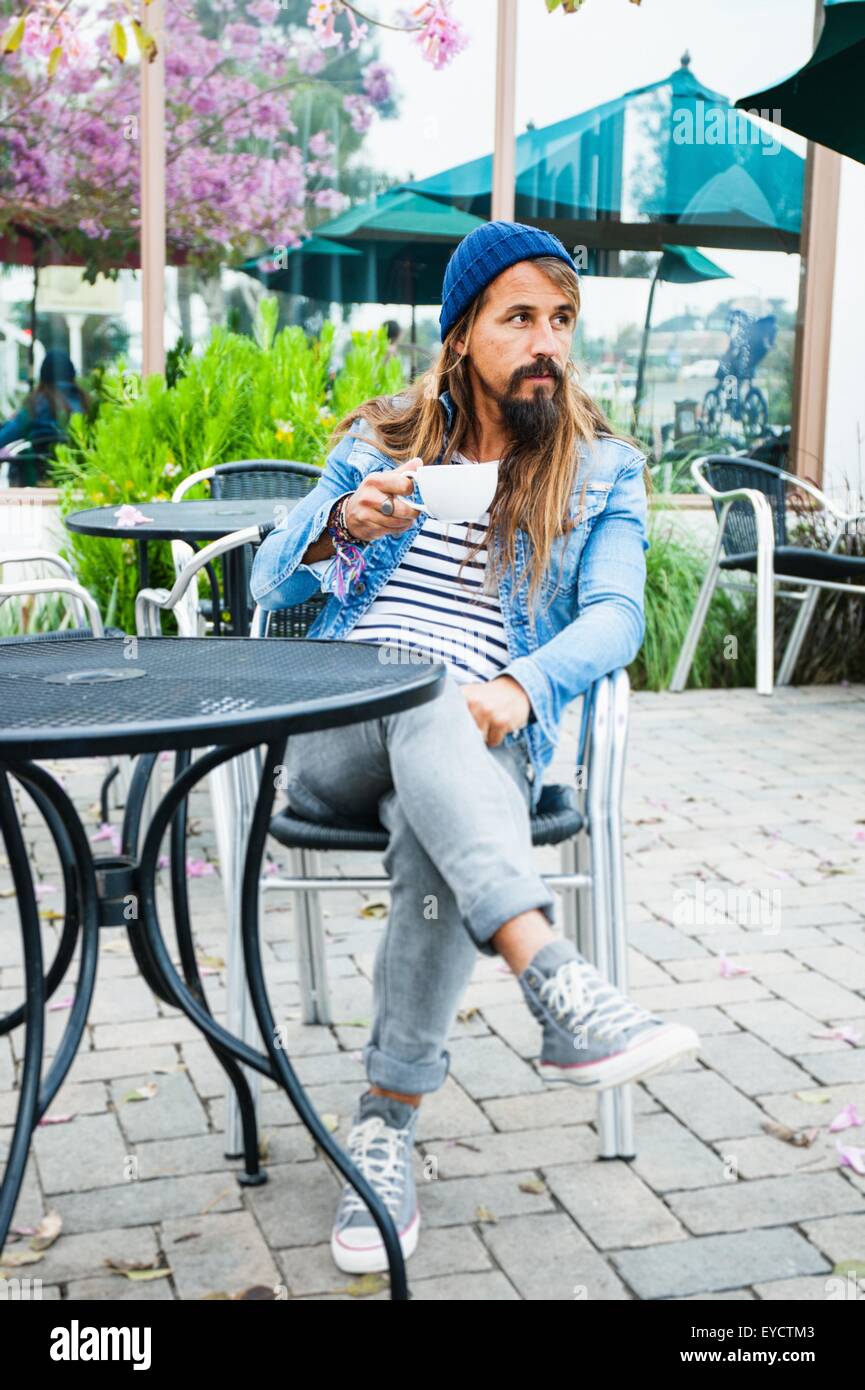Metà uomo adulto seduto nella caffetteria con caffè Foto Stock