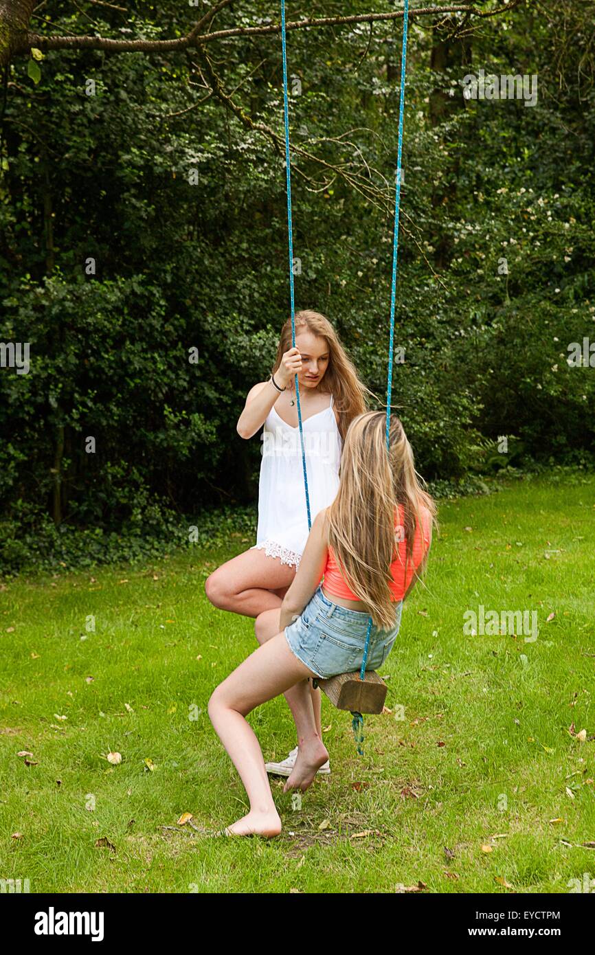 Due ragazze adolescenti giocando su swing Foto Stock