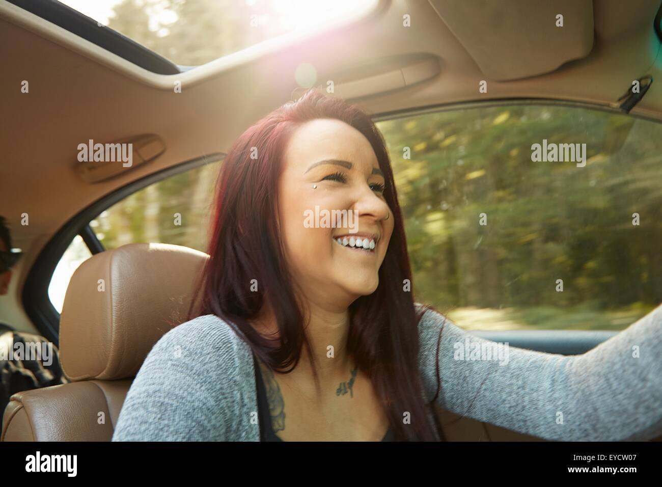 Sorridente giovane donna alla guida di auto Foto Stock