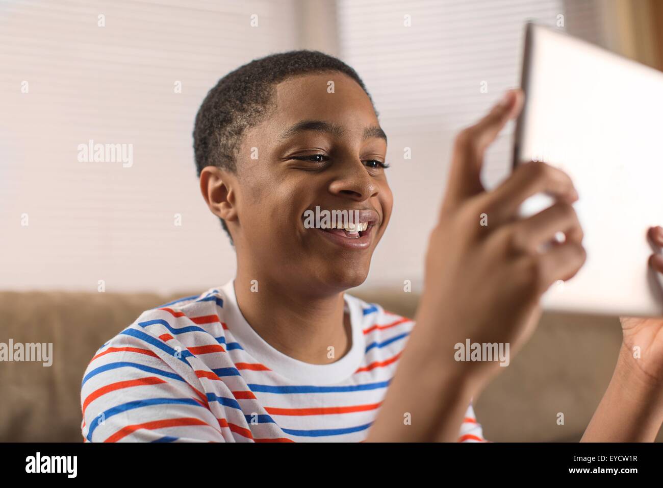 Ragazzo adolescente che posano per una tavoletta digitale selfie sul divano Foto Stock