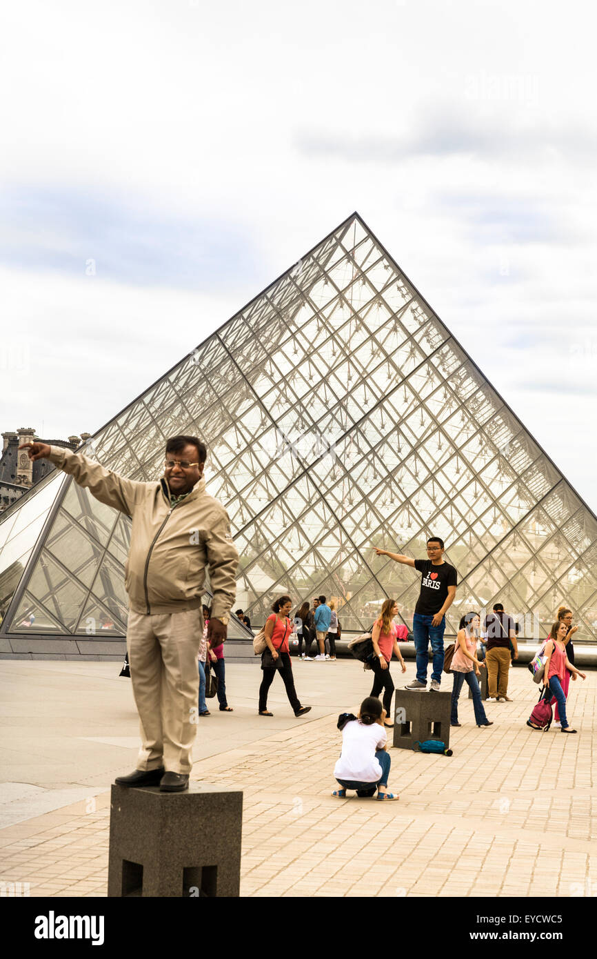I turisti pongono dal famoso Museo del Louvre piramide in vetro a Parigi, Francia Foto Stock