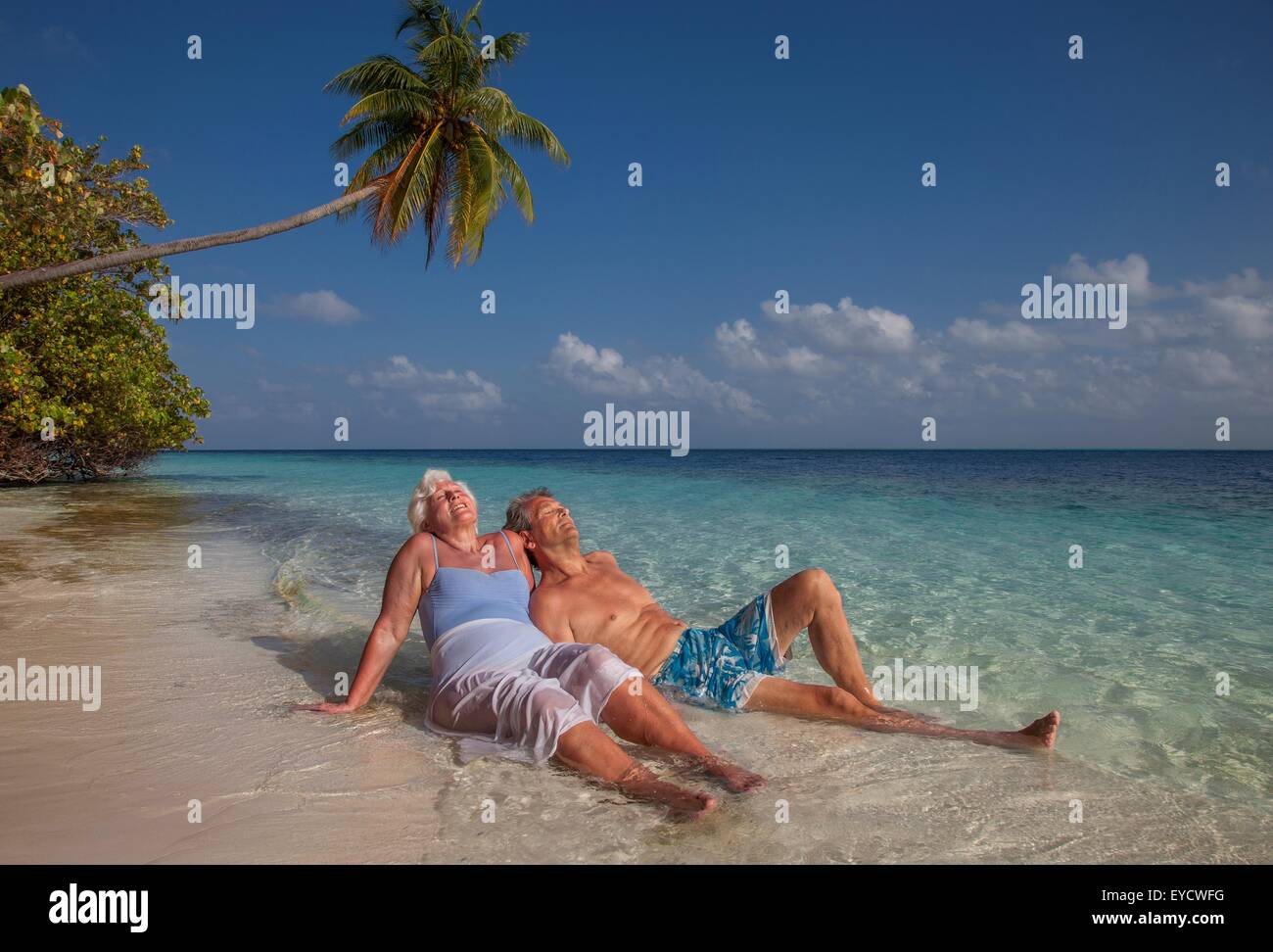Coppia senior relax sulla spiaggia, Maldive Foto Stock