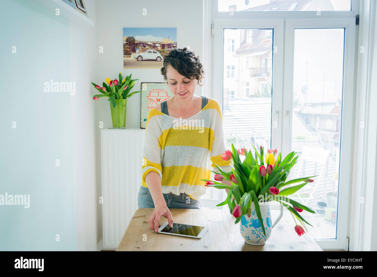 Donna con tavoletta digitale in casa Foto Stock