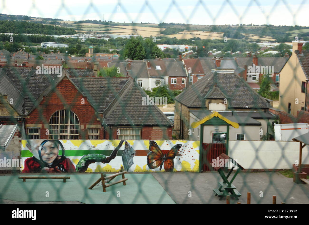Un area gioco per bambini visto attraverso la scherma a Rotherham guardando al Eastwood area della città, South Yorkshire Regno Unito Foto Stock