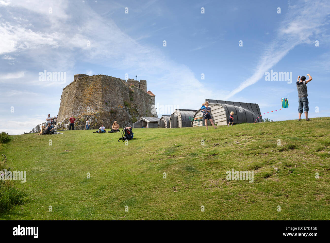 Ai visitatori di rilassarsi e giocare al di sotto di Lindisfarne Castle Foto Stock