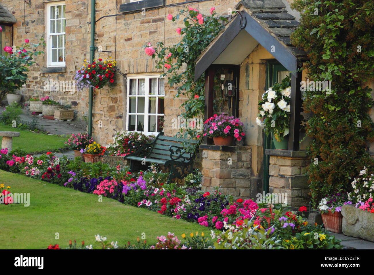 Britannico tradizionale in pietra costruite case con giardino incontaminato le frontiere in un inglese estate village, South Yorkshire, Inghilterra, Regno Unito Foto Stock