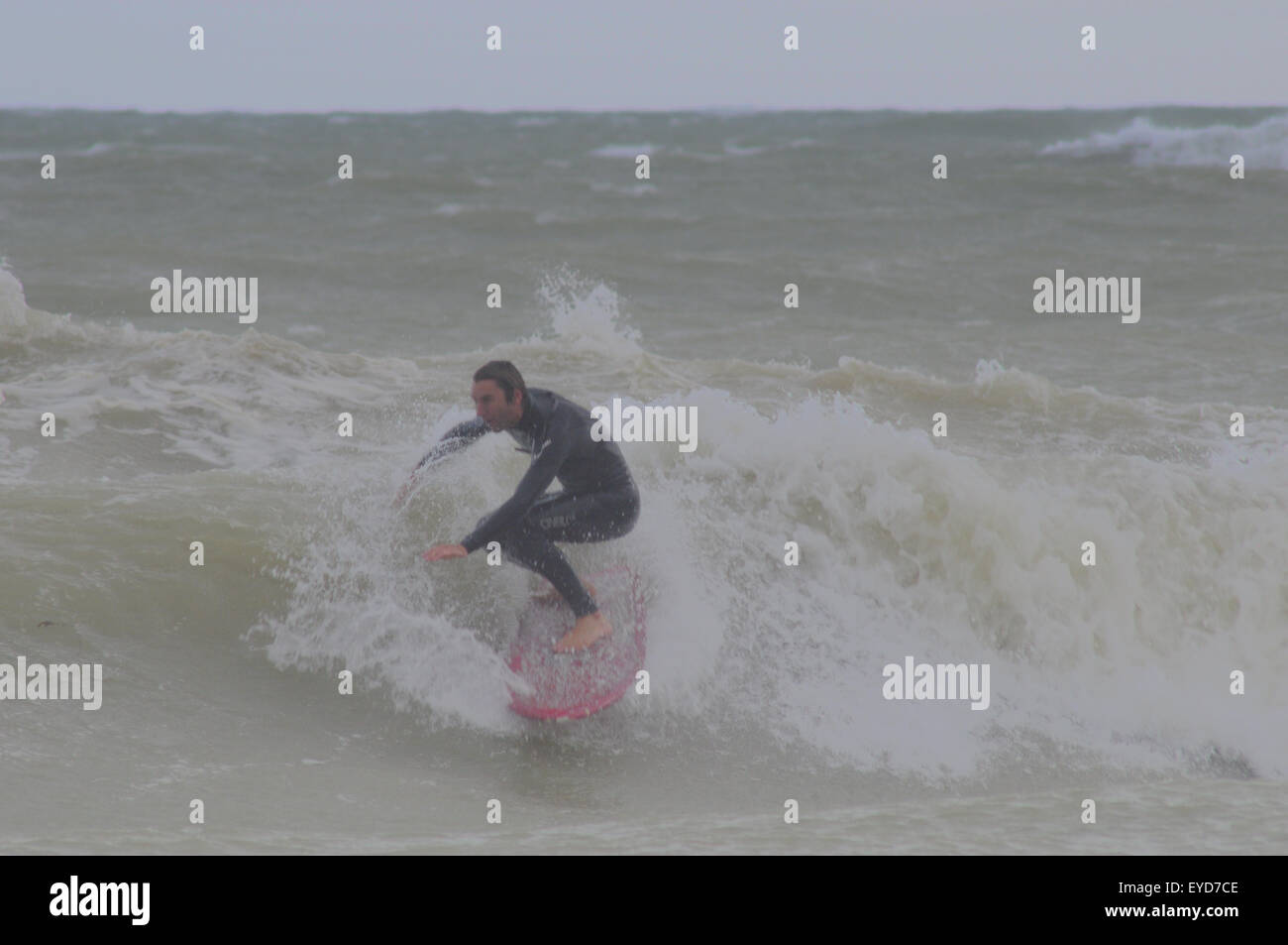 Shoreham, East Sussex, Regno Unito. 27 Luglio 2015. Surfer ottiene un'onda fuori da Southwick Beach Foto Stock