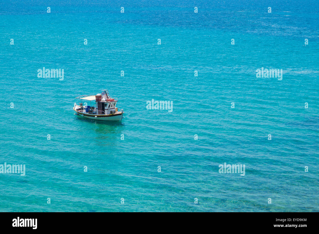 Una barca solitario in un luminoso blu del mare Foto Stock