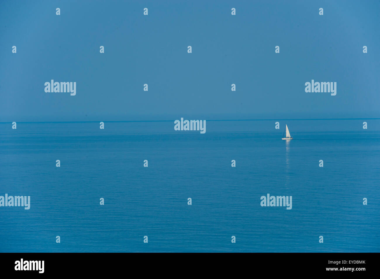 Una barca solitario in un luminoso blu del mare Foto Stock
