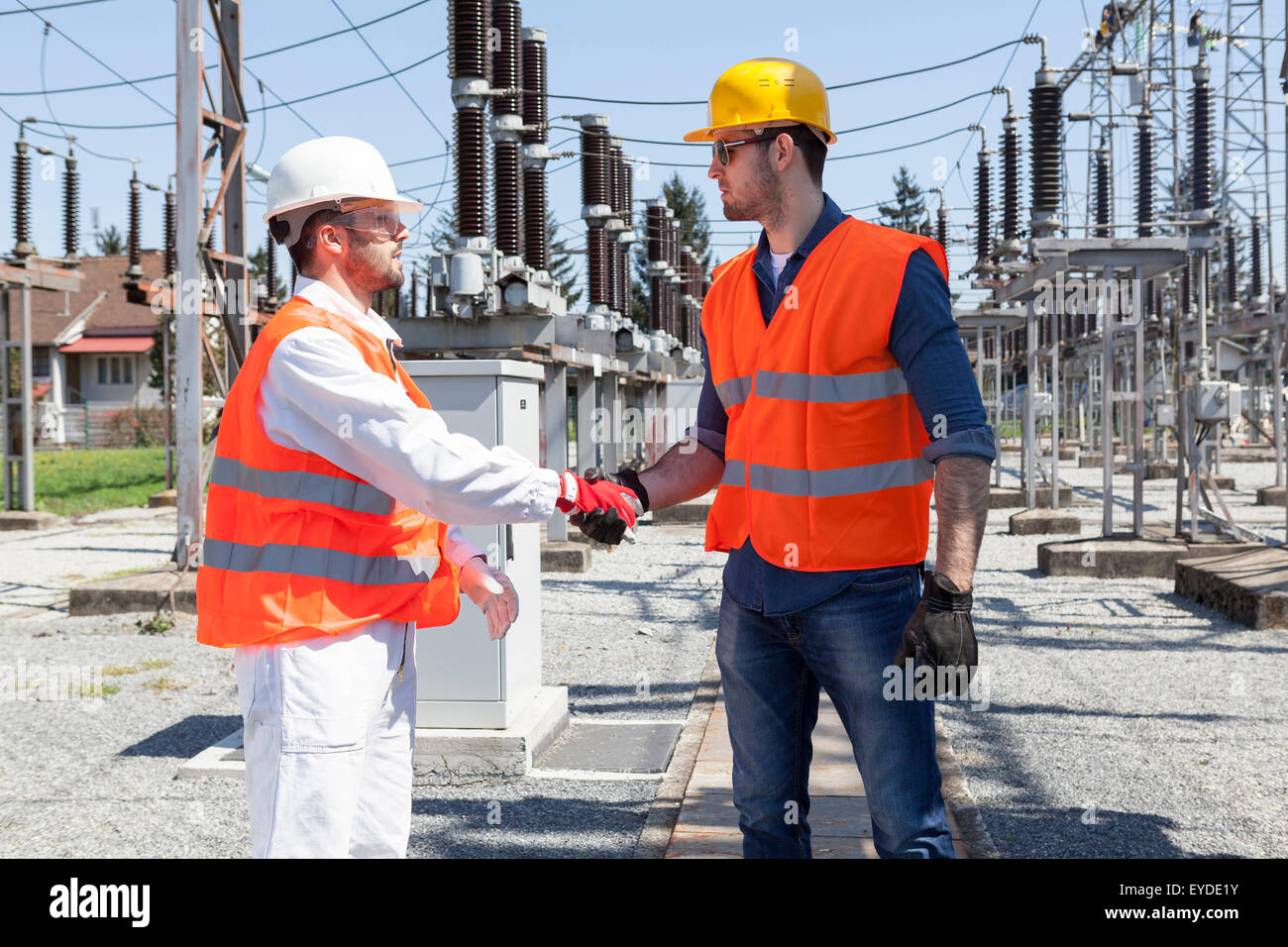 Due ingegneri si stringono la mano dalla sottostazione elettrica Foto Stock