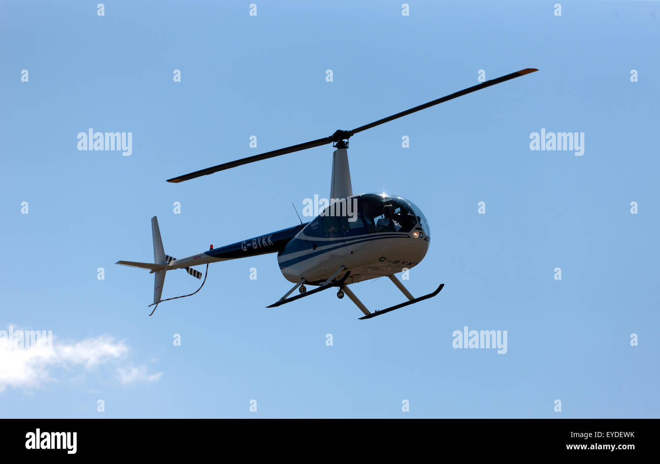 Un R44 elicottero volo diporto, tenendo il passo oltre la pista, durante la Silverstone Classic. Foto Stock