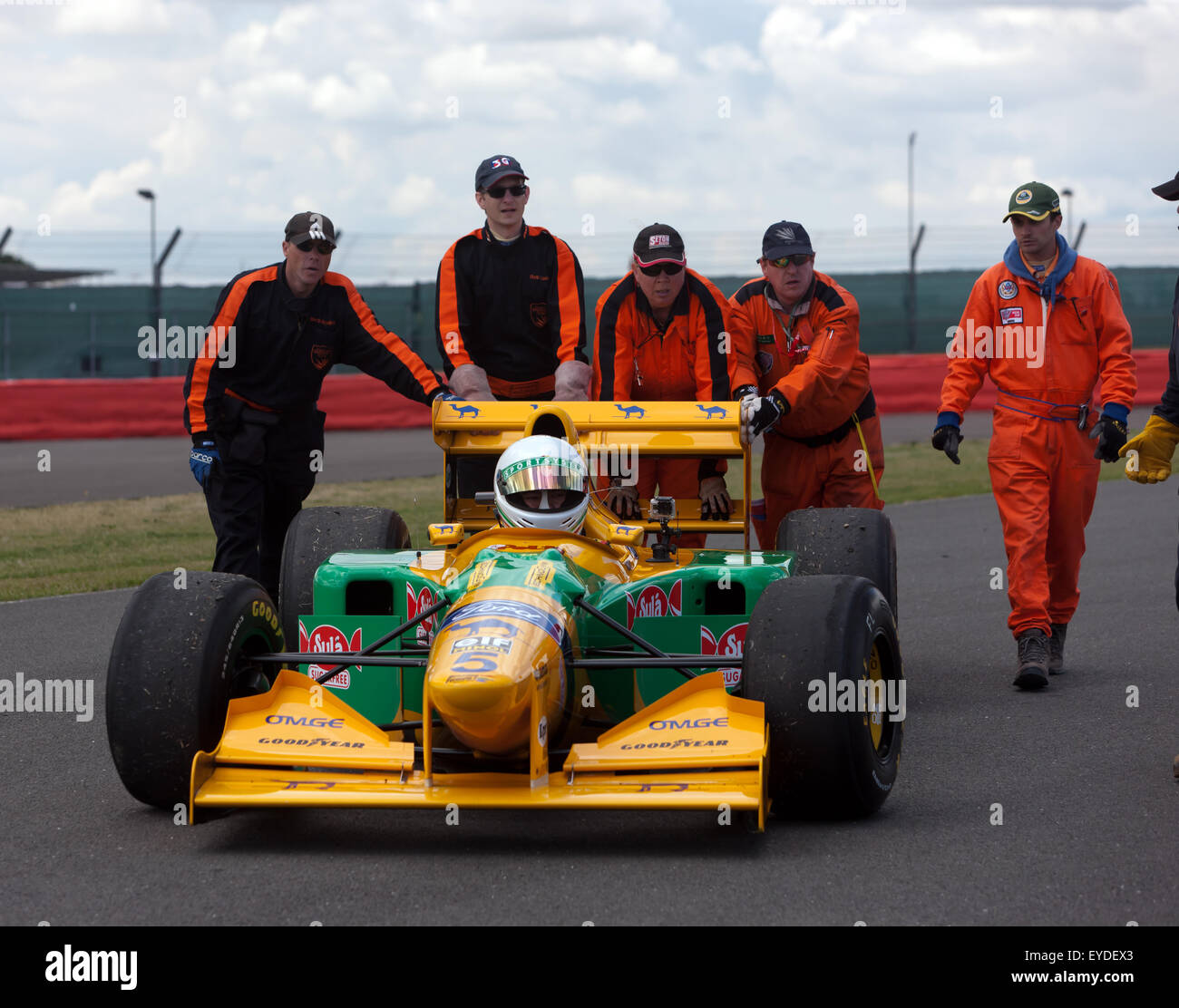 Esegue il marshalling di recuperare un 1993, Formula One Benetton B193, dalla pista durante una sessione di dimostrazione a Silverstone Classic Foto Stock