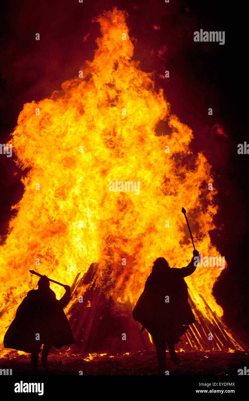 Silhouette di Uomini vestiti come soldati normanno di fronte a grandi falò sulla spiaggia, Hastings notte dei falò, East Sussex, Regno Unito Foto Stock