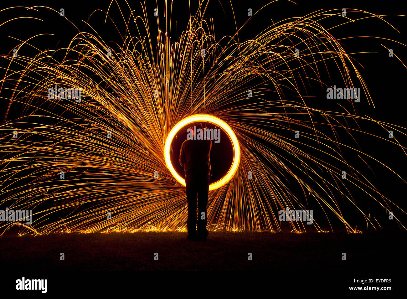 Uomo sfera di filatura per la masterizzazione di lana di acciaio durante la notte, Petersfield, Hampshire, Regno Unito Foto Stock