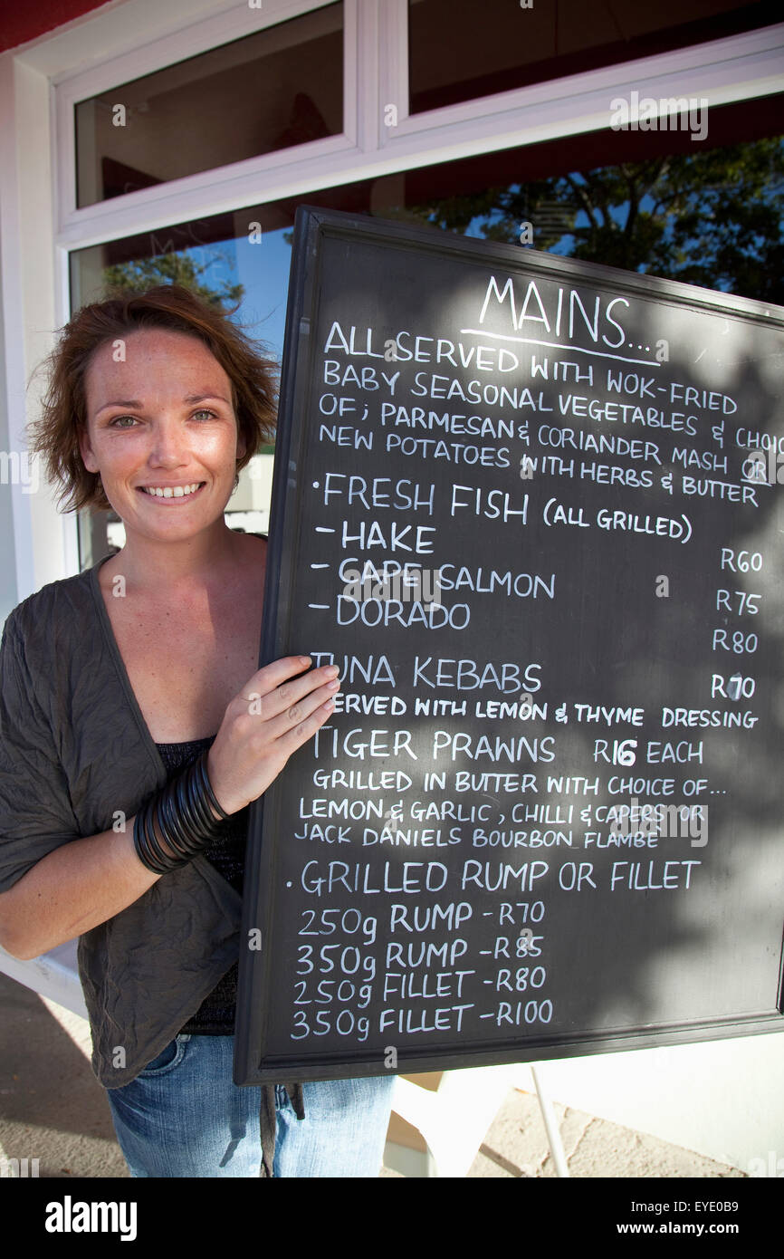 Sud Africa Garden Route, Donna Mostra Menu Blackboard nella anima gemella ristorante di pesce; Port Elizabeth Foto Stock