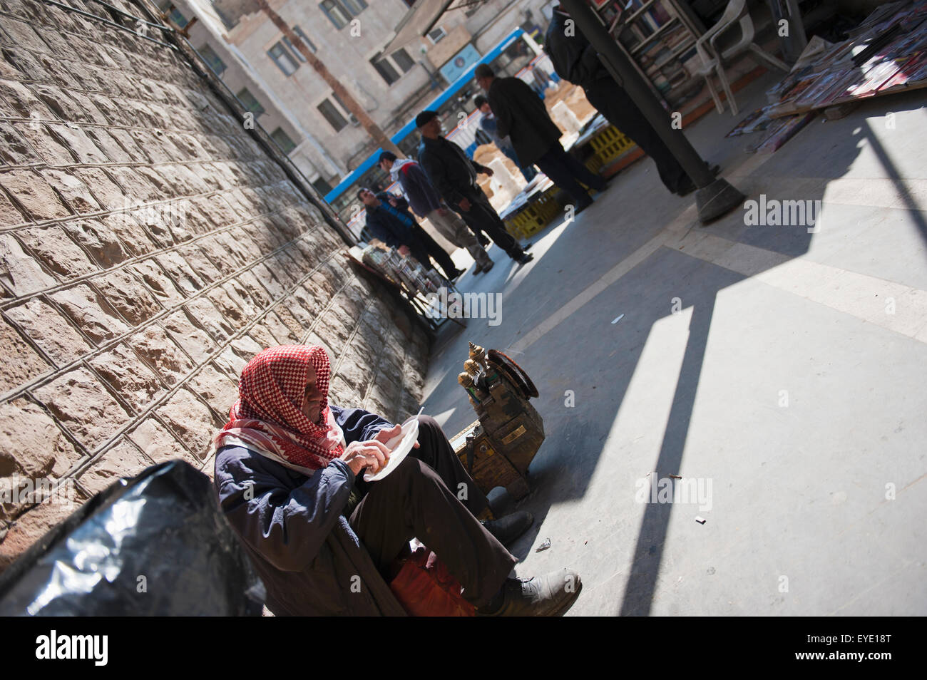 Uomo locale si infila in una fetta di Kunafeh fuori Habibah arabo negozio di dolci, Amman, Giordania, Medio Oriente Foto Stock