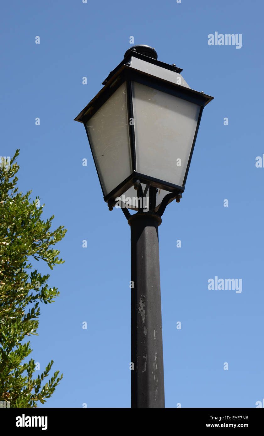 Vecchia lampada posta contro un cielo blu Foto Stock