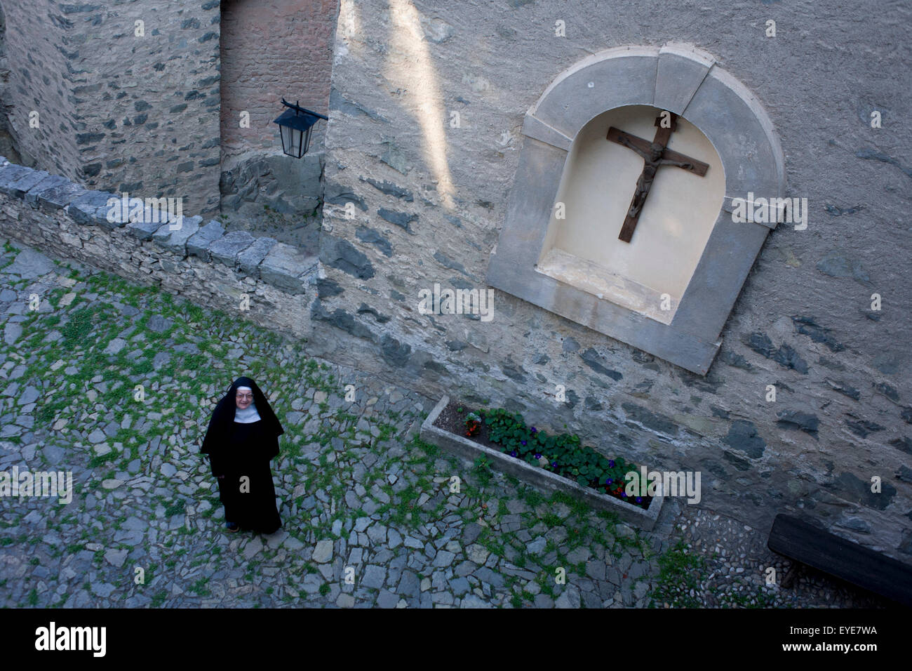 Una suora guarda dal cortile a Sabiona Abbazia in Klausen, Alto Adige, Italia. Sabiona abbazia è un monastero benedettino istituito nel 1687, quando per la prima volta è stata risolta dalle monache dell'Abbazia di Nonnberg a Salisburgo. Foto Stock