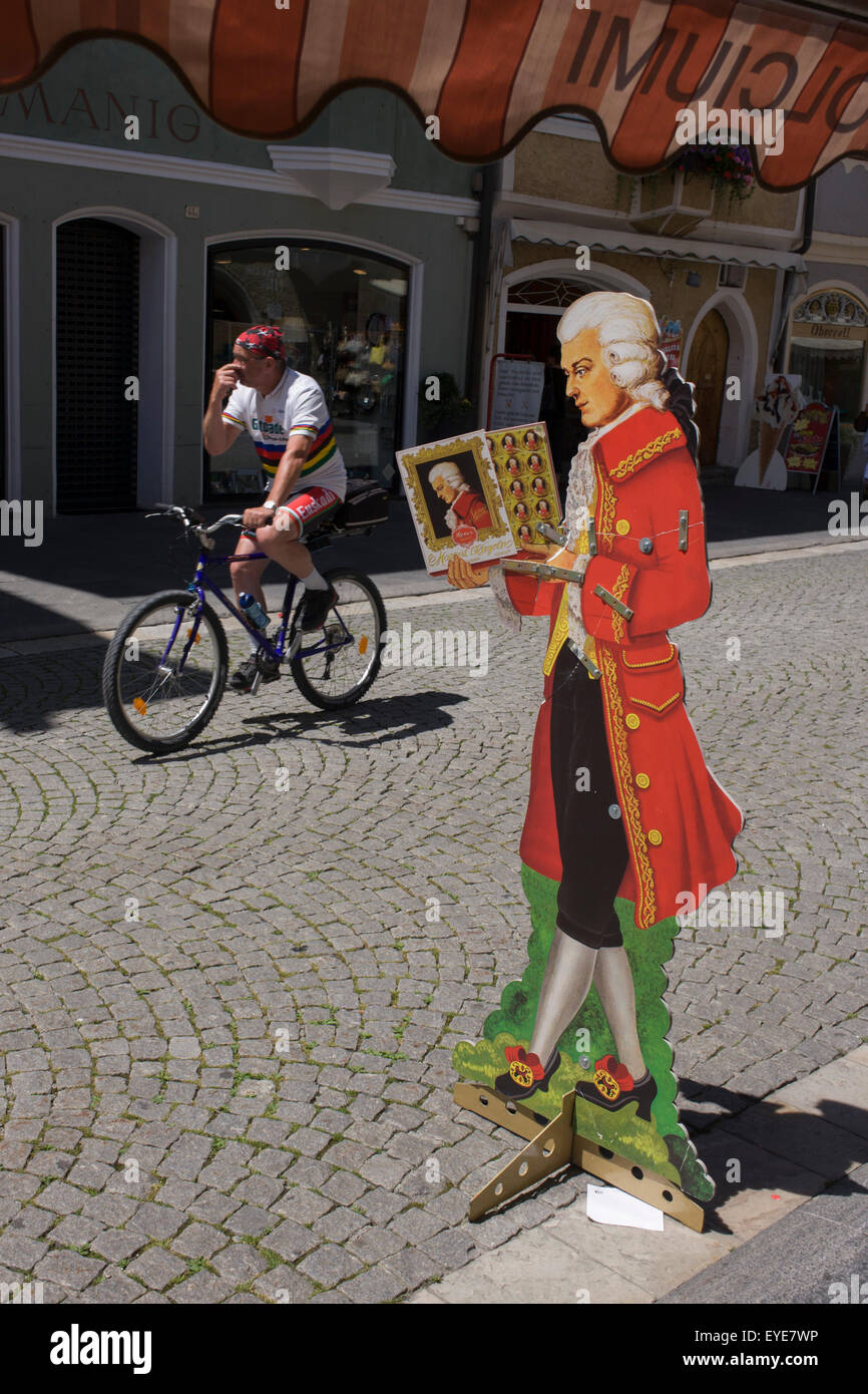 Life-size cut-out del compositore austriaco Wolfgang Amadeus Mozart e il passaggio di un ciclista italiano nella città di confine di Sterzing-Vipiteno in Alto Adige. Foto Stock