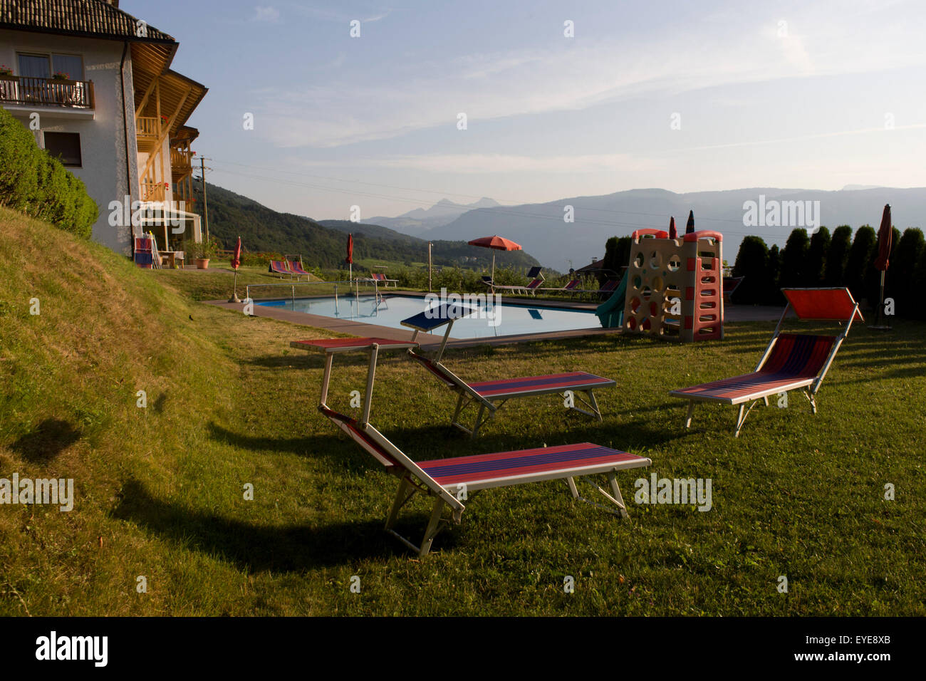 La mattina presto a bordo piscina lettini per prendere il sole in un country hotel nelle Dolomiti, rurale Alto Adige, a sud-ovest di Bolzano, Itally. Foto Stock