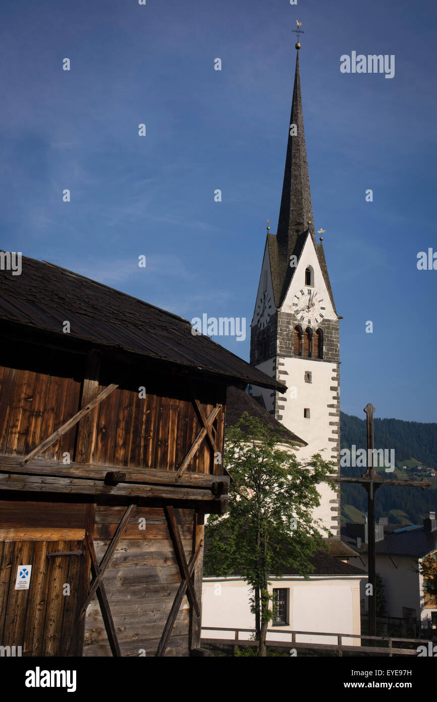Dolomiti di tipica architettura della chiesa e di legname e il fienile in Leonhard-St Leonardo, un villaggio delle Dolomiti in Alto Adige, Italia. Foto Stock