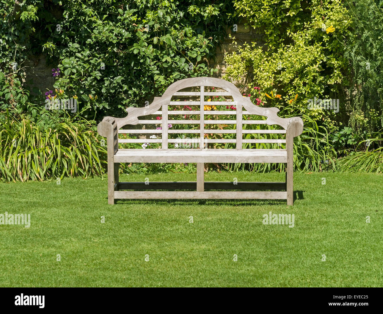 Ornati da giardino in legno sedile unico sul prato verde, Barnsdale Gardens, Rutland, England, Regno Unito Foto Stock